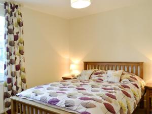 a bedroom with a bed with a colorful quilt at 14 Greta Villas in Keswick