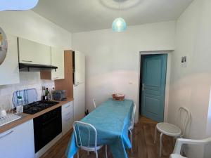 a kitchen with a table with a blue blanket on it at Casa Marie in Sampolo