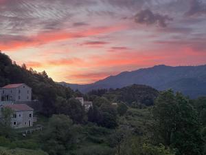 a sunset in the mountains with houses and trees at Casa Marie in Sampolo