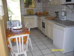 a small kitchen with a table and chairs in it at laréunion in Maison Henou