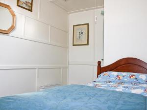 a bedroom with a bed with a blue comforter at Flagstaff Cottage in Robin Hood's Bay +2 photos