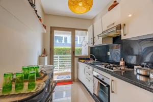 a kitchen with a counter with green bottles on it at Spacious luxury apartment with pool in Bouznika