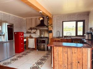 a kitchen with a large wooden island in the middle at Casa con vista a los volcanes y Lago Llanquihue in Puerto Varas +9 photos