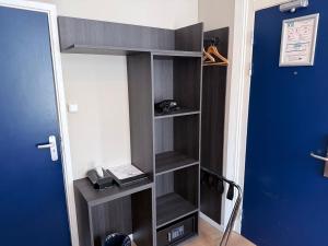 un estante de libros en una habitación al lado de una puerta en The Crown Hotel, en Ámsterdam