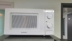 세인트빌리지 في Kup'o: فرن الميكروويف الأبيض موجود فوق المنضدة +صورة واحدة