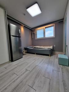 세인트빌리지 في Kup'o: غرفة كبيرة فيها ثلاجة وسرير