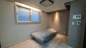 세인트빌리지 في Kup'o: غرفة نوم صغيرة بها سرير ونافذة