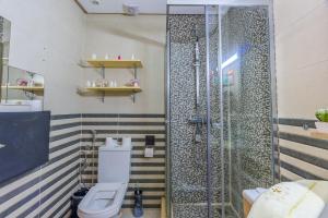 a bathroom with a toilet and a shower at Spacious luxury apartment with pool in Bouznika +23 photos