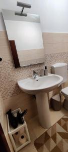a bathroom with a white sink and a toilet at L'approdo in Schisò