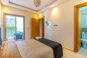 a bedroom with a bed and a bathroom at Spacious luxury apartment with pool in Bouznika