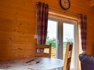 a dining room with a table and a clock on the wall at Raynard's Retreat - Uk33401 in Hungerton
