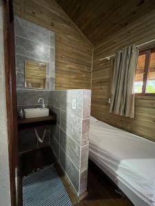 a small bathroom with a bed and a sink at Voila Hostel in Florianópolis