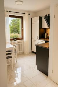 a kitchen with a table and a dining room at Modernes Apartment mit 180° Bergblick in Buchenberg