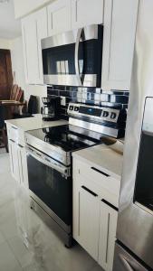 a kitchen with a black stove and white cabinets at My Relaxing place! in North Fort Myers +29 photos