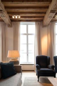 ein Wohnzimmer mit einer Couch und einem Sessel und einem Fenster in der Unterkunft House of De Swaen Apartments in Breda