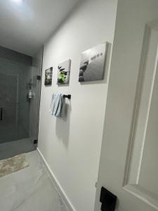 a bathroom with a white wall with pictures on it at My Relaxing place! in North Fort Myers