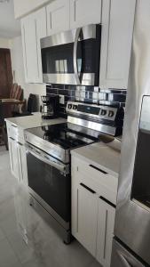 a kitchen with stainless steel appliances and white cabinets at My Relaxing place! in North Fort Myers