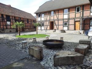 a courtyard with a fire pit in front of a building at Mario's fachwerkhaus am Huy in Schlanstedt