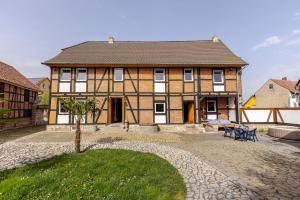 a large house with a courtyard in front of it at Mario's fachwerkhaus am Huy in Schlanstedt