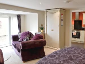 a living room with a couch and a chair at Stable Cottage in Penrhyn Bay