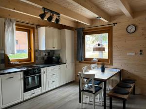 a kitchen with a table and a clock on the wall at chata Malina in Martin
