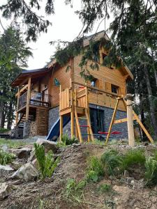 a large wooden house with a porch and a playground at chata Malina in Martin