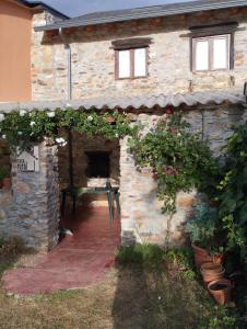 an outside view of a stone building with flowers at Rincón del Bierzo in Borrenes
