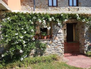 an old stone building with flowers on it at Rincón del Bierzo in Borrenes