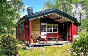 a red tiny house with a table and chairs at Amazing Home In Knäred in Knäred +16 photos