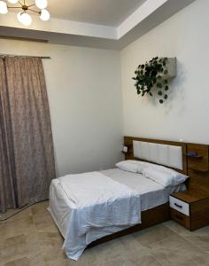 - une chambre avec un lit et une plante sur le mur dans l'établissement Amer Group Villas and Chalets on the Pool, à Ain Sokhna