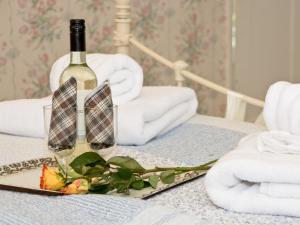 a bottle of wine and towels on a bed at Greenlands Farmhouse in Barmby on the Moor +12 photos