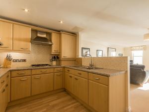 a kitchen with wooden cabinets and a sink at 13 Great Cliff in Dawlish