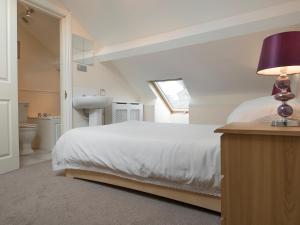 a bedroom with a bed and a sink and a window at Esthwaite in Windermere