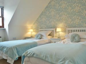 a bedroom with two beds with blue and white at Herdwick Heights in Keswick