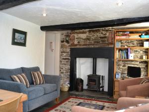 ein Wohnzimmer mit Couch und Kamin in der Unterkunft Blease Cottage in Threlkeld