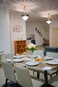 - une table à manger avec des chaises et des fleurs dans l'établissement Arte Plus Jalan Ampang with KLCC View, à Kuala Lumpur