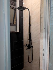 a shower with a black shower head in a bathroom at Hakuna Matata Apartment in Munyonyo in Kampala +28 photos