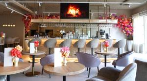 a restaurant with tables and chairs and a fireplace at Hotel Alkmaar - Bar & Restaurant in Alkmaar
