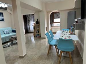 a living room with a table and blue chairs at Geany Apartament Ultracentral in Craiova