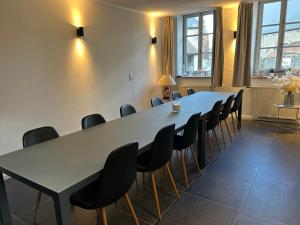 a meeting room with a long table and chairs at Maison de la Fontaine in Hierges