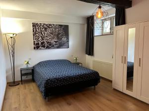 a bedroom with a bed and a painting on the wall at Maison de la Fontaine in Hierges +33 photos