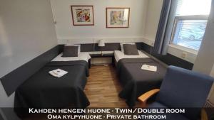a small room with two beds and two chairs at Hotel 24 - Karihaara - Kemi in Kemi +26 photos