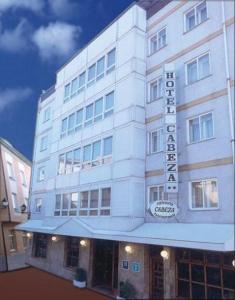 a white building with a hotel sign on it at Hotel Cabeza in Noreña