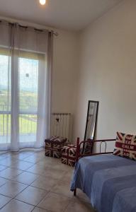 a bedroom with a bed and a large window at Casa Adelaide - A stone's throw from Rome in Gavignano