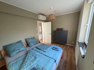 a bedroom with a large bed with blue sheets at Ferienhaus Christa in Neukieritzsch