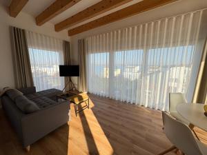 a living room with a couch and large windows at Ferienhaus Christa in Neukieritzsch