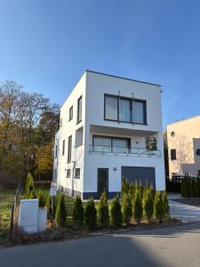 a white building with trees in front of it at Ferienhaus Christa in Neukieritzsch