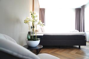 a bedroom with a bed and a table with a plant at Hotel Alkmaar - Bar & Restaurant in Alkmaar