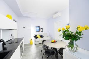 a kitchen and living room with a table and yellow flowers at Suite Andrea-Luxury Central Suite in Bergamo