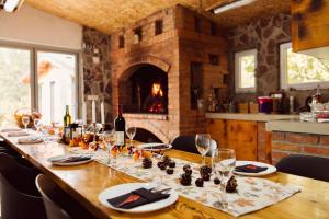 a long wooden table with wine glasses and a fireplace at Srce Kozare in Prijedor